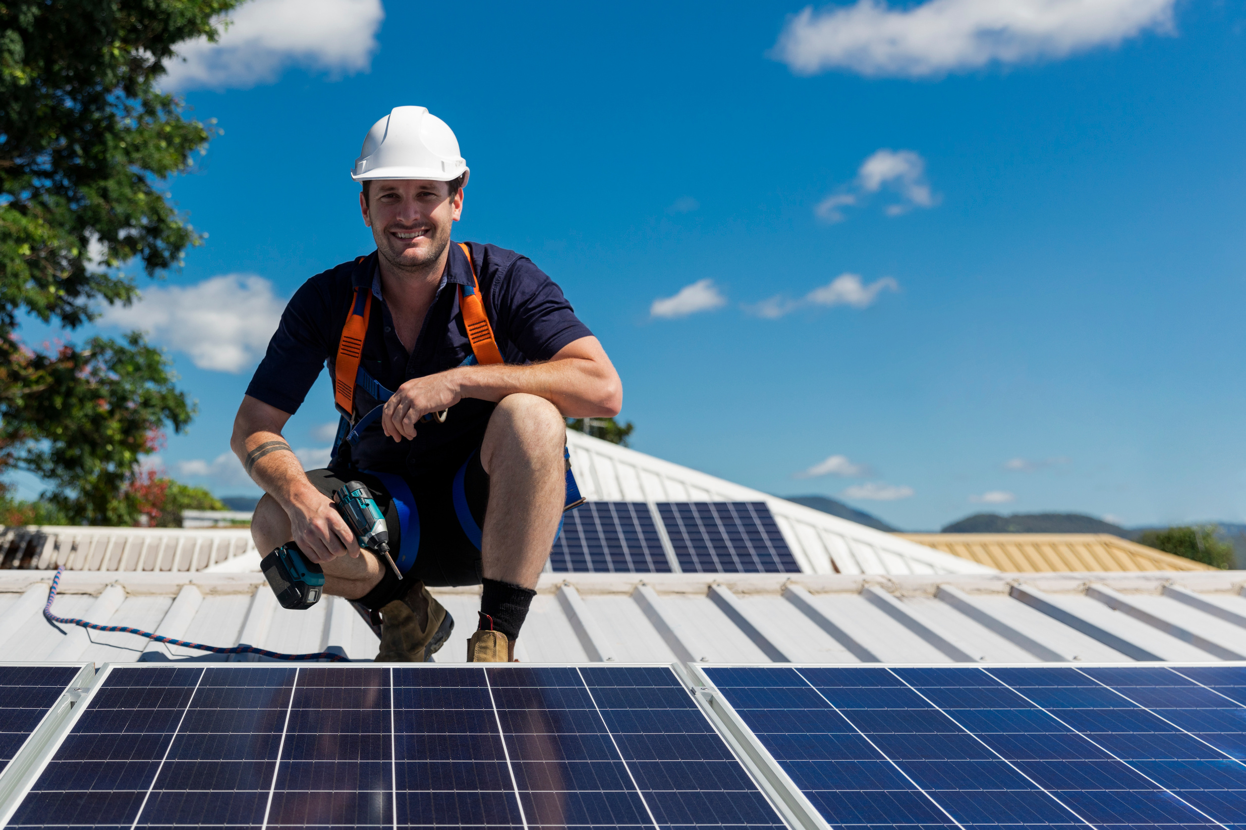 Solar Panel Technician with Drill Installing Solar Panels
